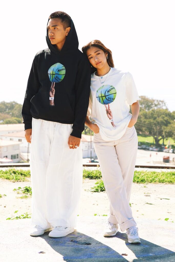 Stylish couple posing in urban Los Angeles, showcasing trendy hoodies and casual outfits.